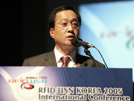 Shin Bae Kim, chairman of the RFID Association, is shown delivering the keynote speech (Chairman Kim gave a keynote speech on the subject of `Korea`s Vision for the Ubiquitous World`. This occurred in the `RFID/USN KOREA 2005` event that took place in the COEX Building in Samsung-dong).